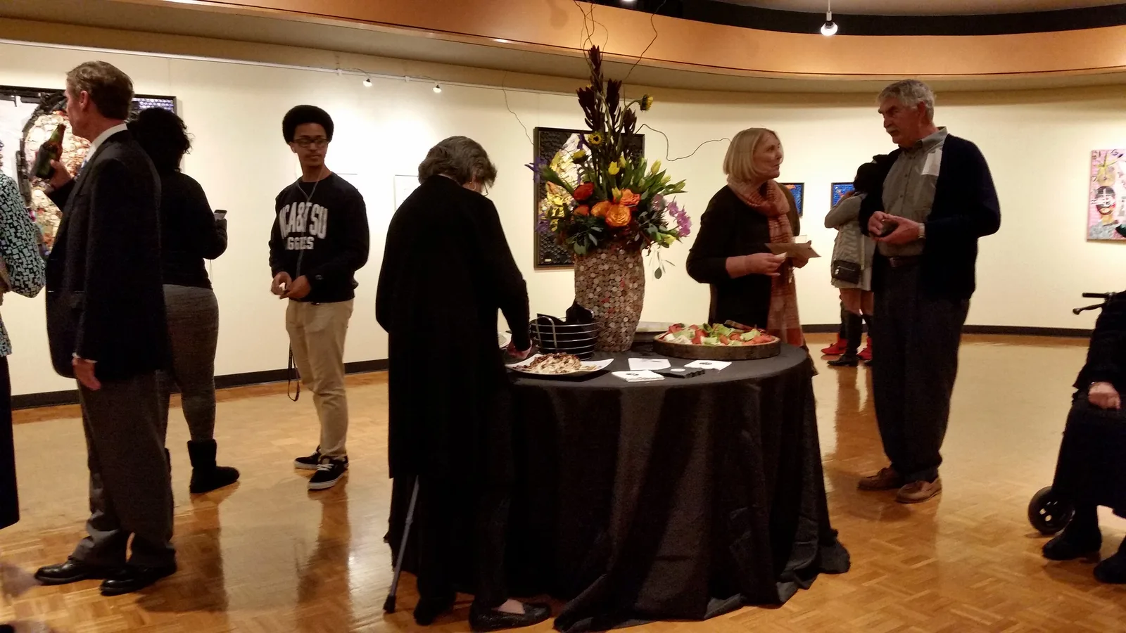 Guests at an art show opening reception in the gallery at the High Point Theatre.