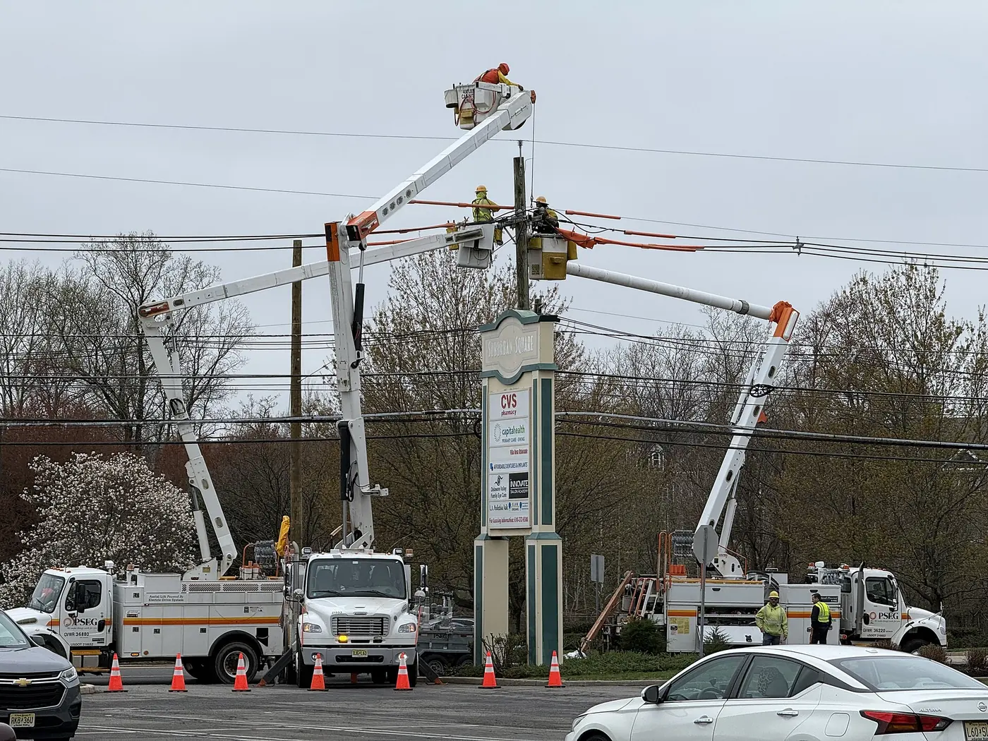 Lineworkers in bucket trucks repair lines on a utility pole in Ewing Township, New Jersey.