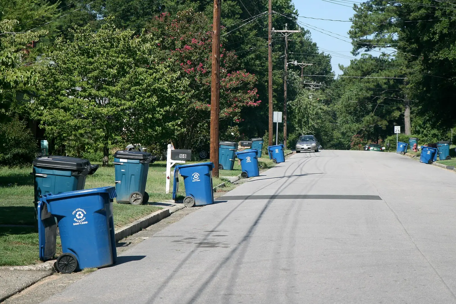 Trash and recycling roll carts set out at the curb on a residential street in Durham, N.C., the same roll-cart system High Point uses.
