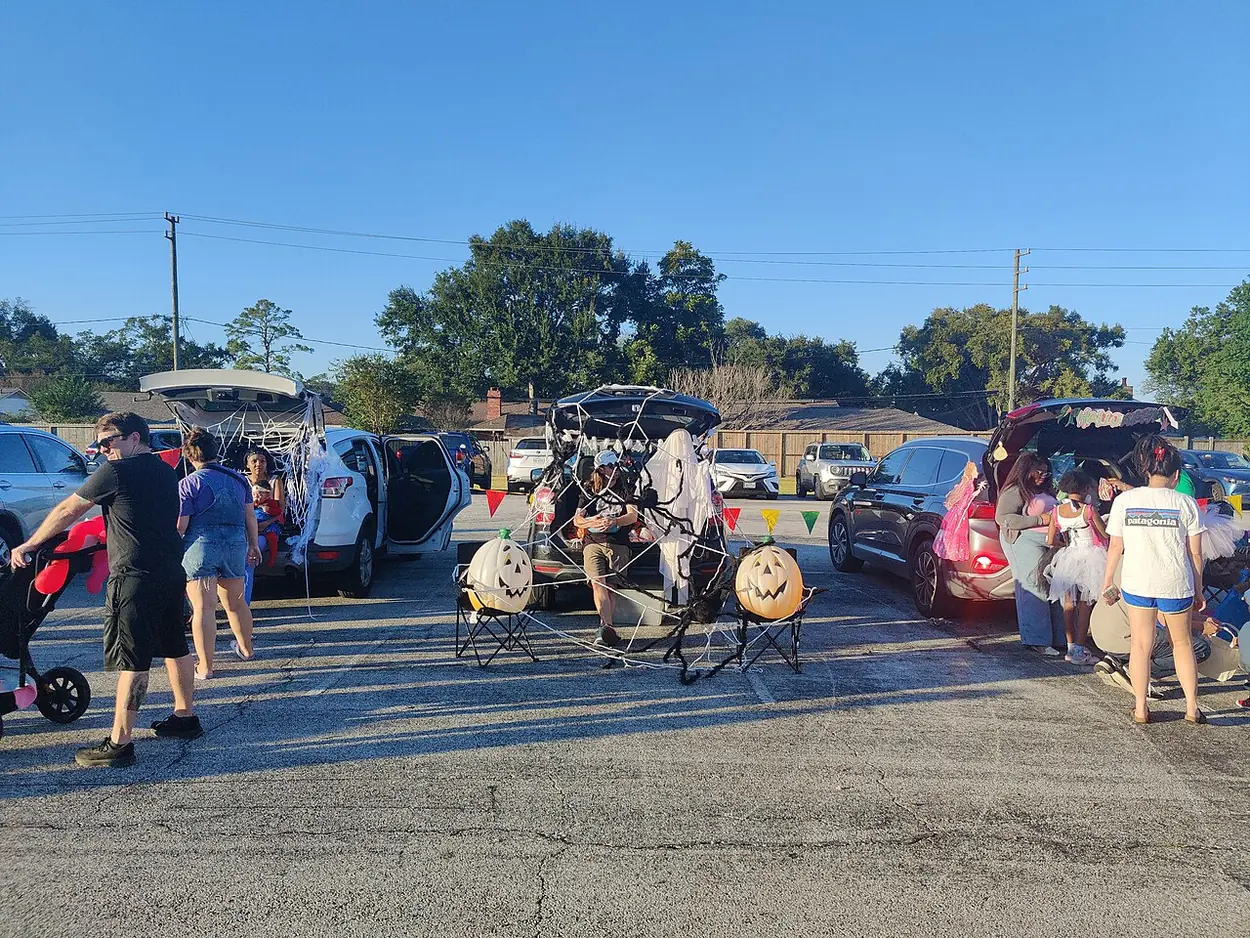 Decorated cars and families at a church trunk-or-treat in Houston.