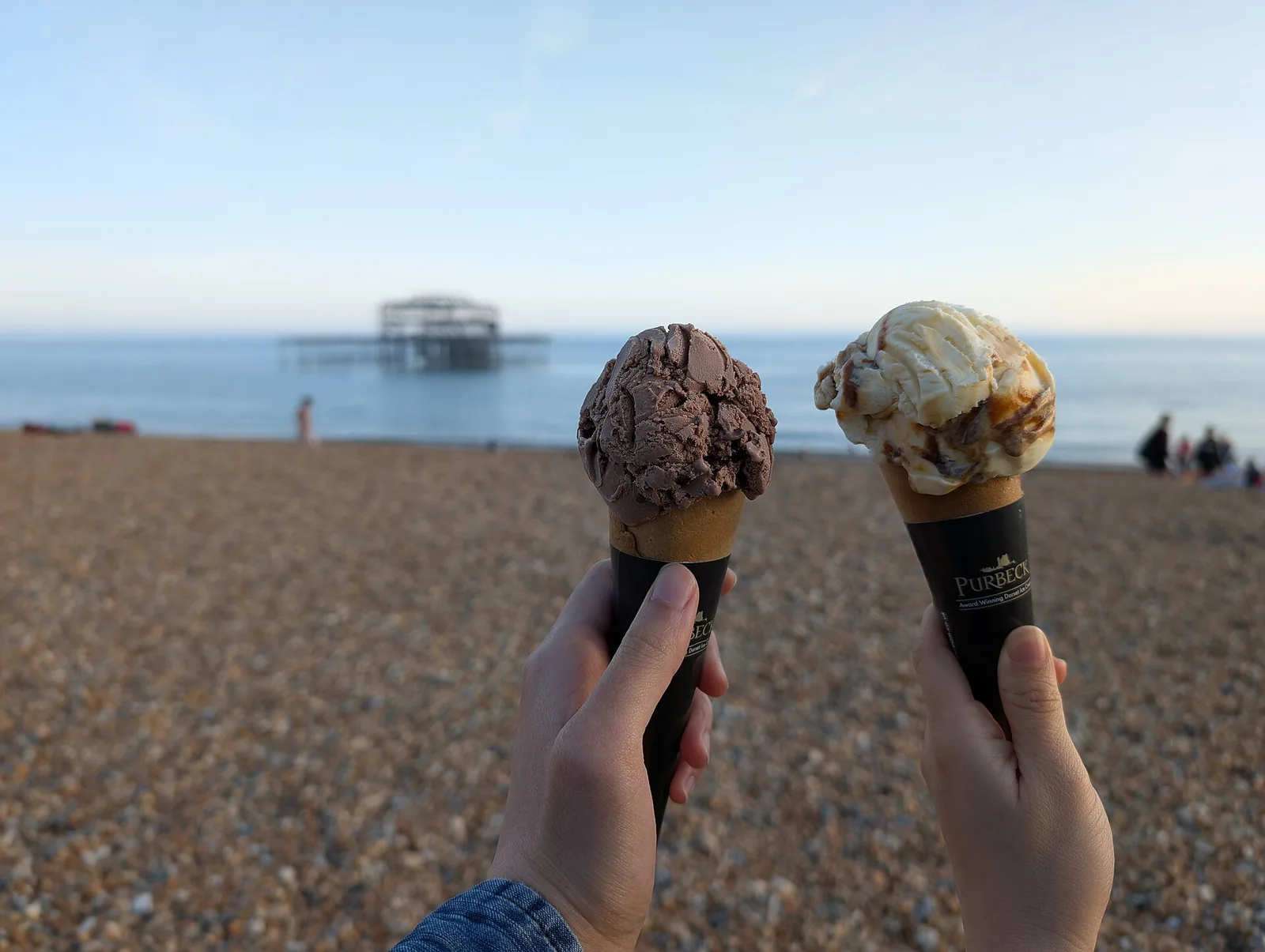 Two ice cream cones held up outdoors. The photo was not taken in High Point.